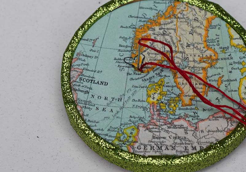 Embroidering the heart on the map ornaments