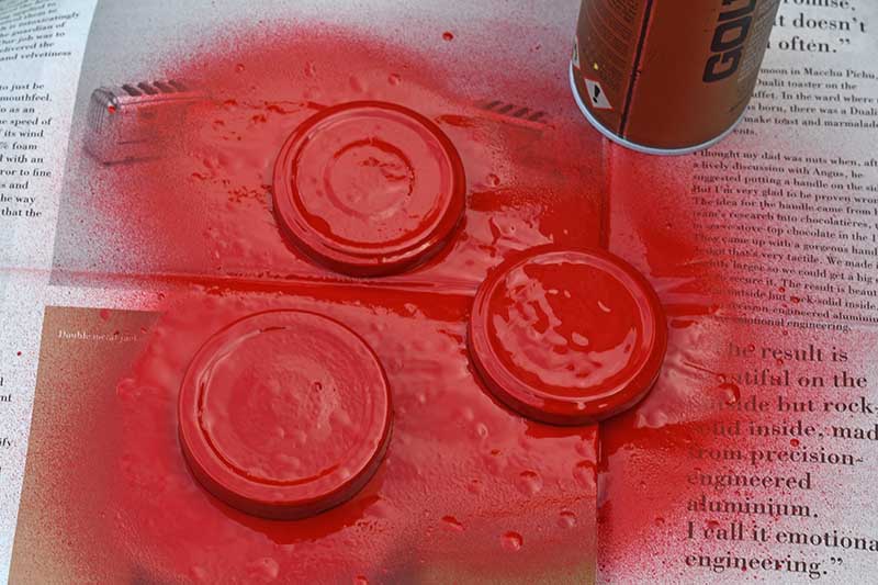 Spray painting lids red.