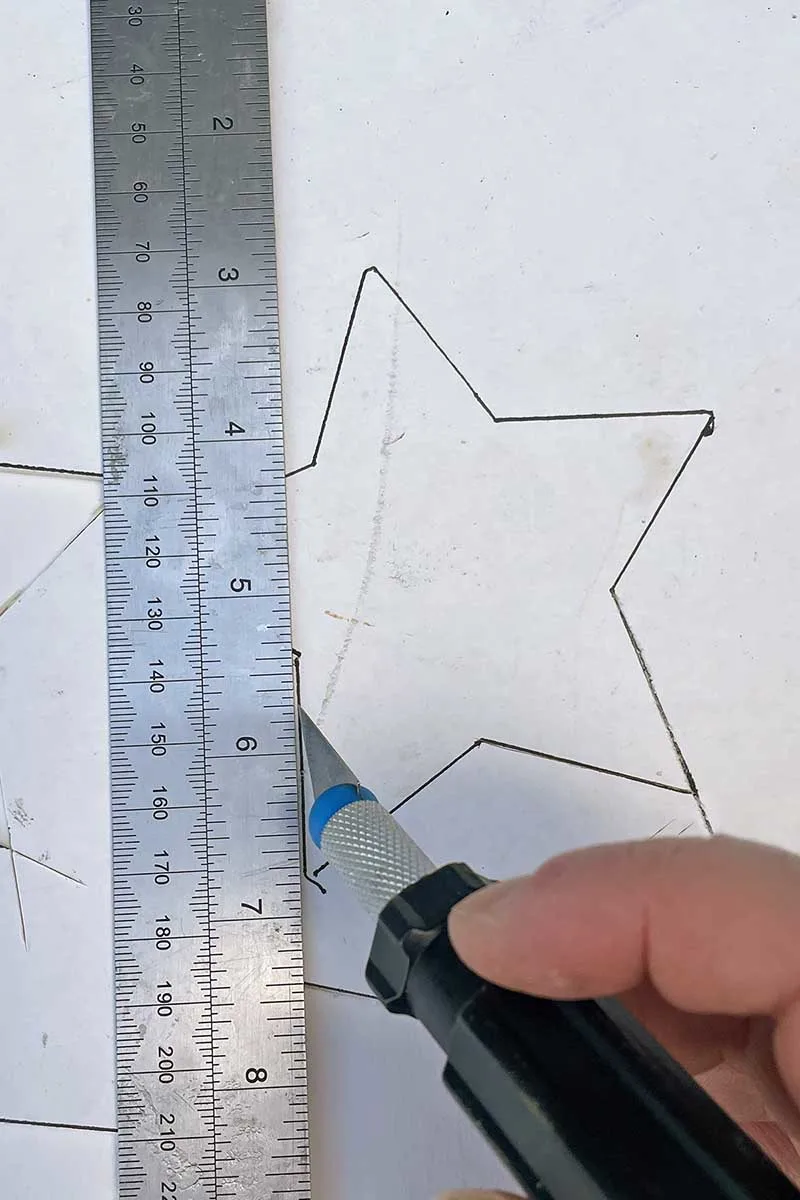 Cutting out cardboard stars to make Zodiac ornaments