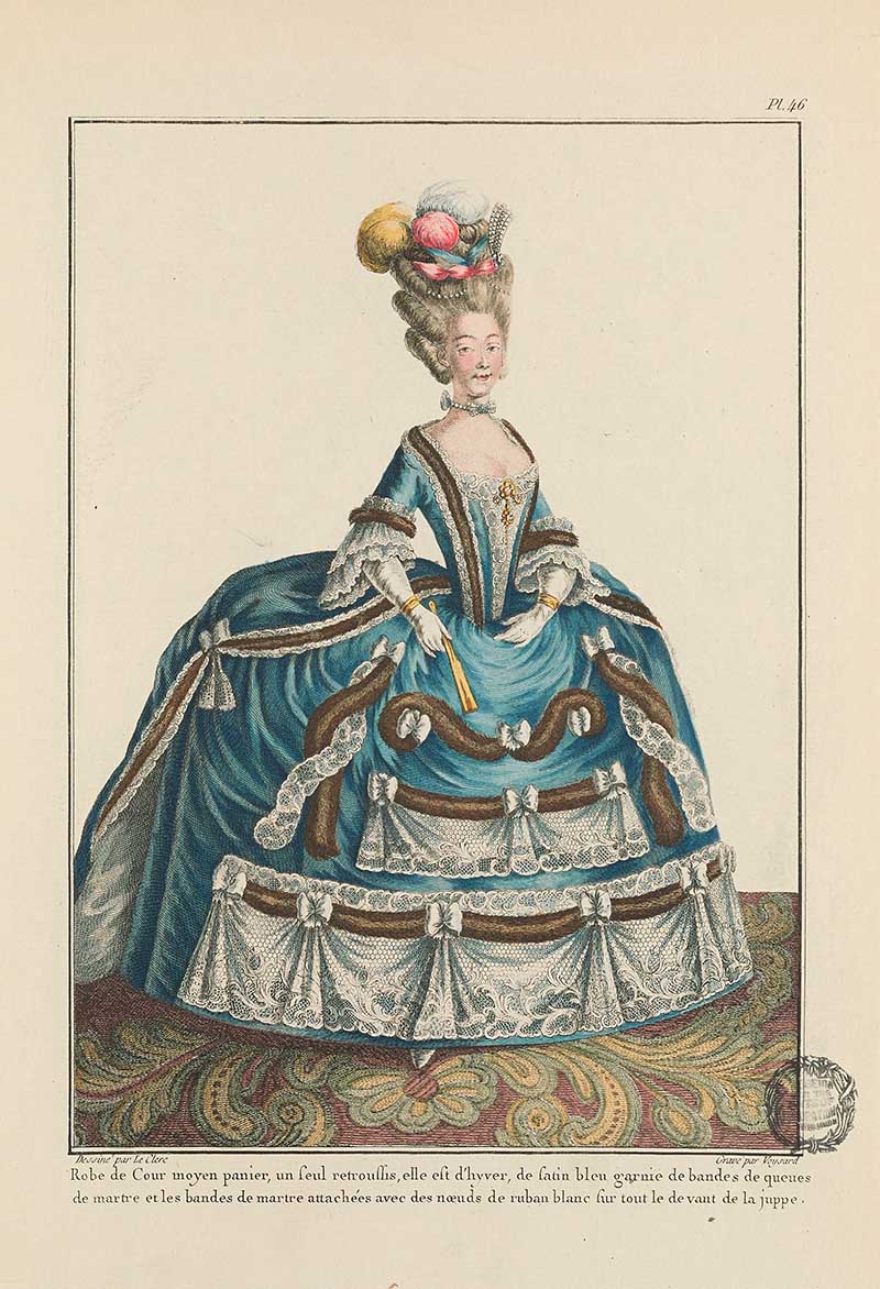 Lady in a grand blue hoop gown with white ruffles, floral headdress, and fan standing on a patterned rug, French Galerie des Modes fashion print 18th century costume illustration