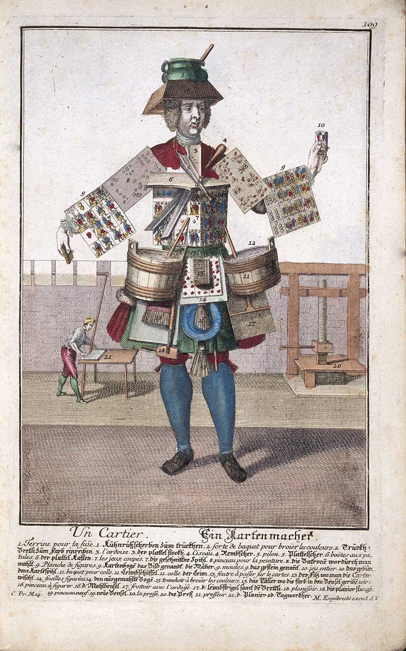 Antique costume print of a chart maker wearing maps and charts, with drawing instruments, rolled papers, buckets, and a workbench in the background.