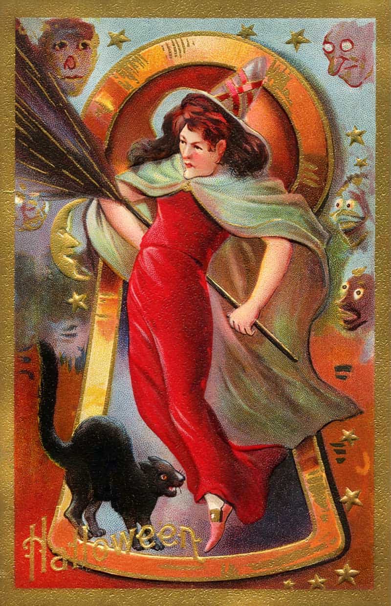 Red witch Halloween postcard with a black cat, skull faces and a gold horseshoe frame.